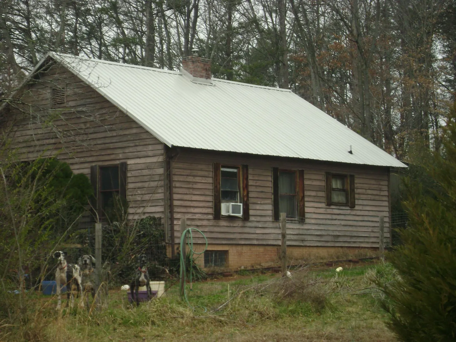White metal roof on an old wood sided farmhouse, from a Metal Roof Installation job in Wind Ridge